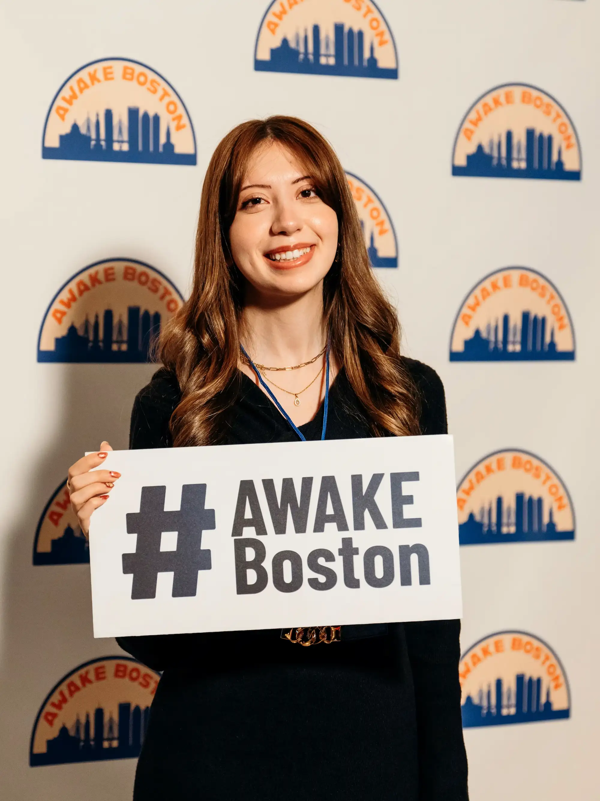 Young woman holding #AWAKE Boston sign at the photo booth, AWAKE America Boston rally