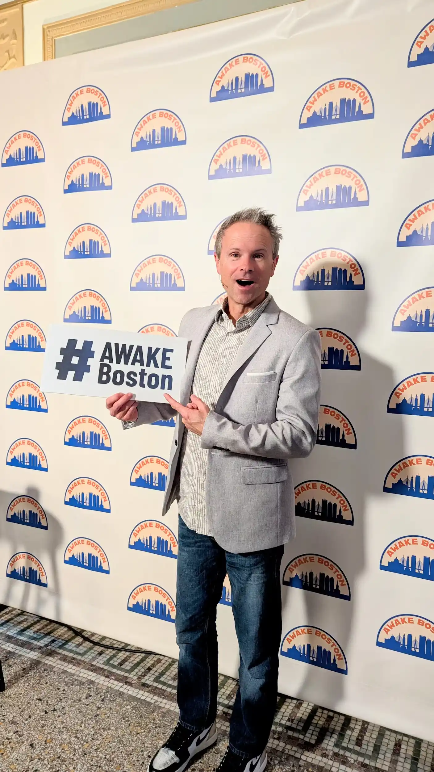 Man holding #AWAKE Boston sign at the photo booth at AWAKE America Boston rally