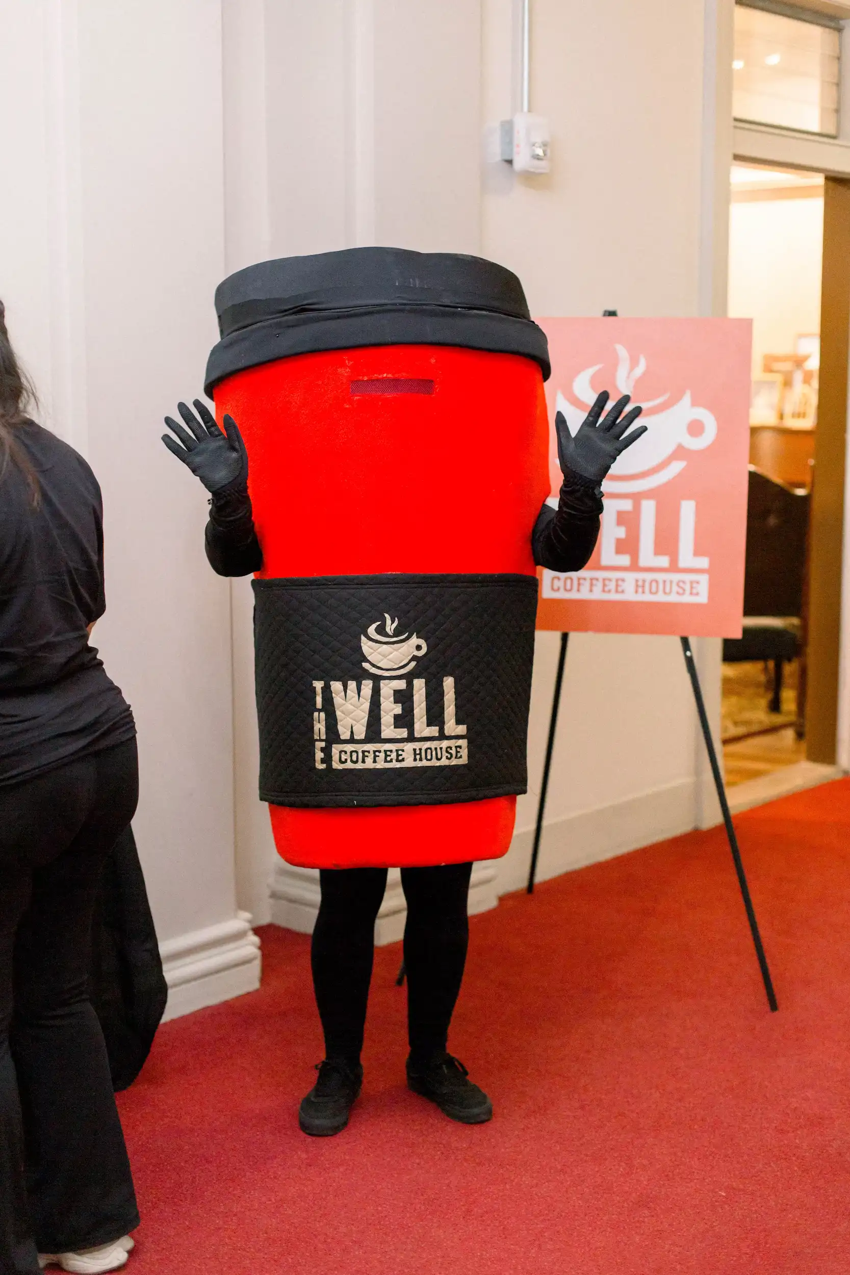 The Well Coffee House mascot in giant coffee cup costume at AWAKE America Boston rally