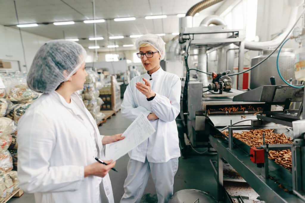 Food production staff in hairnets reviewing the line