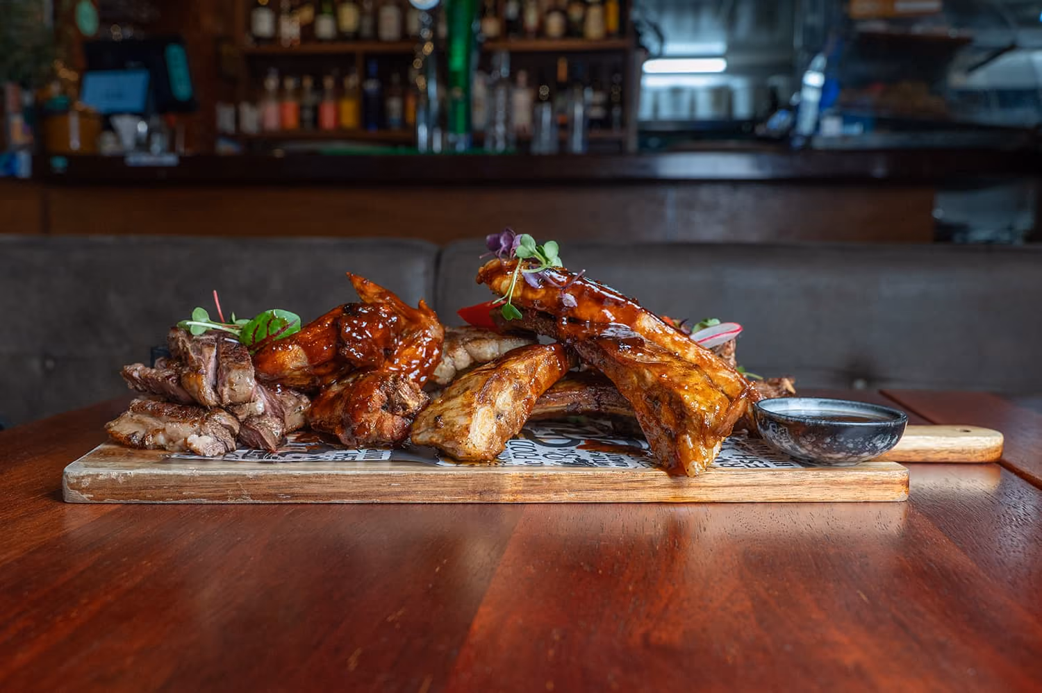 The Olive Kitchen loaded meat board function platter featuring NZ Angus Scotch fillet, lamb cutlets, BBQ glazed pork belly, pork ribs, and fried chicken wings.