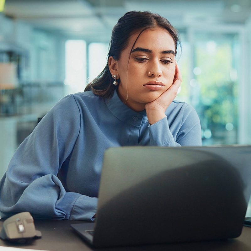 Frustrated office worker looking at her laptop