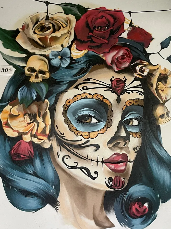 Volto Día de los Muertos con rose e teschi dipinto a mano da Interno Undici, esempio dello stile delle nostre opere