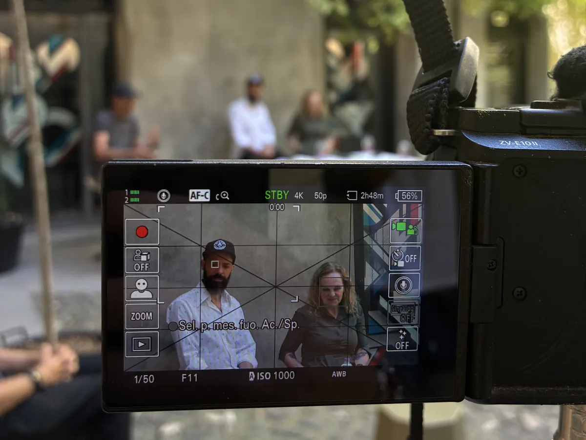 Dietro le quinte: lo schermo di una videocamera durante un'intervista in un cortile