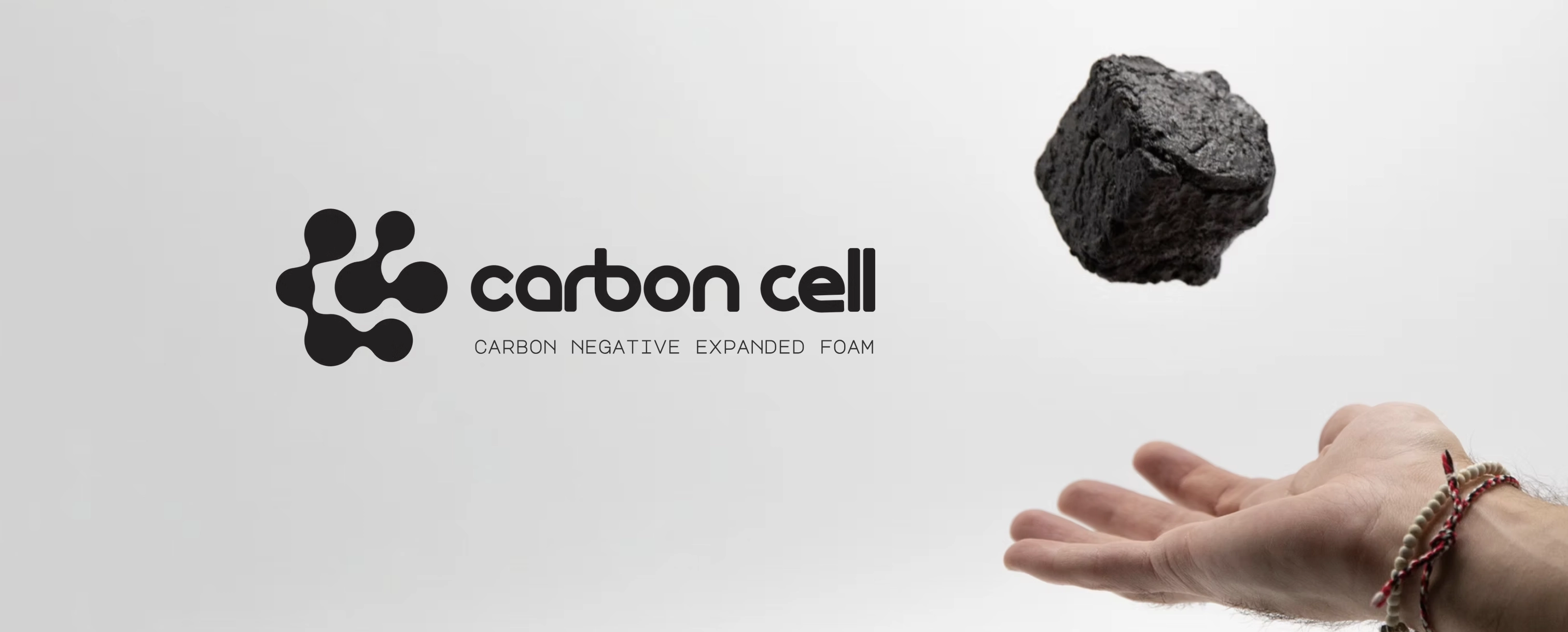 Carbon Cell logo, next to a hand that is throwing a piece of Carbon Cell foam into the air.