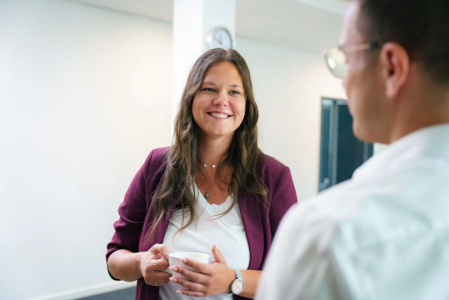 Frau und Mann stehen sich im Büro gegenüber und führen ein Gespräch.
