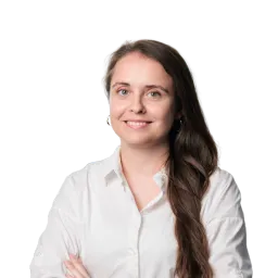 Porträt einer Frau mit langen dunklen Haaren, weißer Bluse und verschränkten Armen.