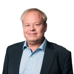 Porträt eines Mannes mit grauen Haaren, dunklem Sakko und hellem Hemd.