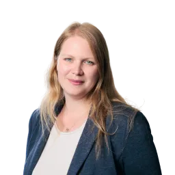 Porträt einer Frau mit langen blonden Haaren, dunklem Blazer und hellem Oberteil.