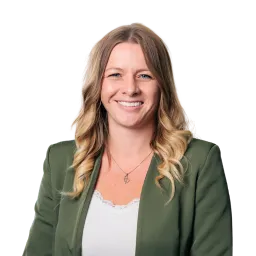 Porträt einer Frau mit langen blonden Haaren, grünem Blazer und hellem Oberteil.