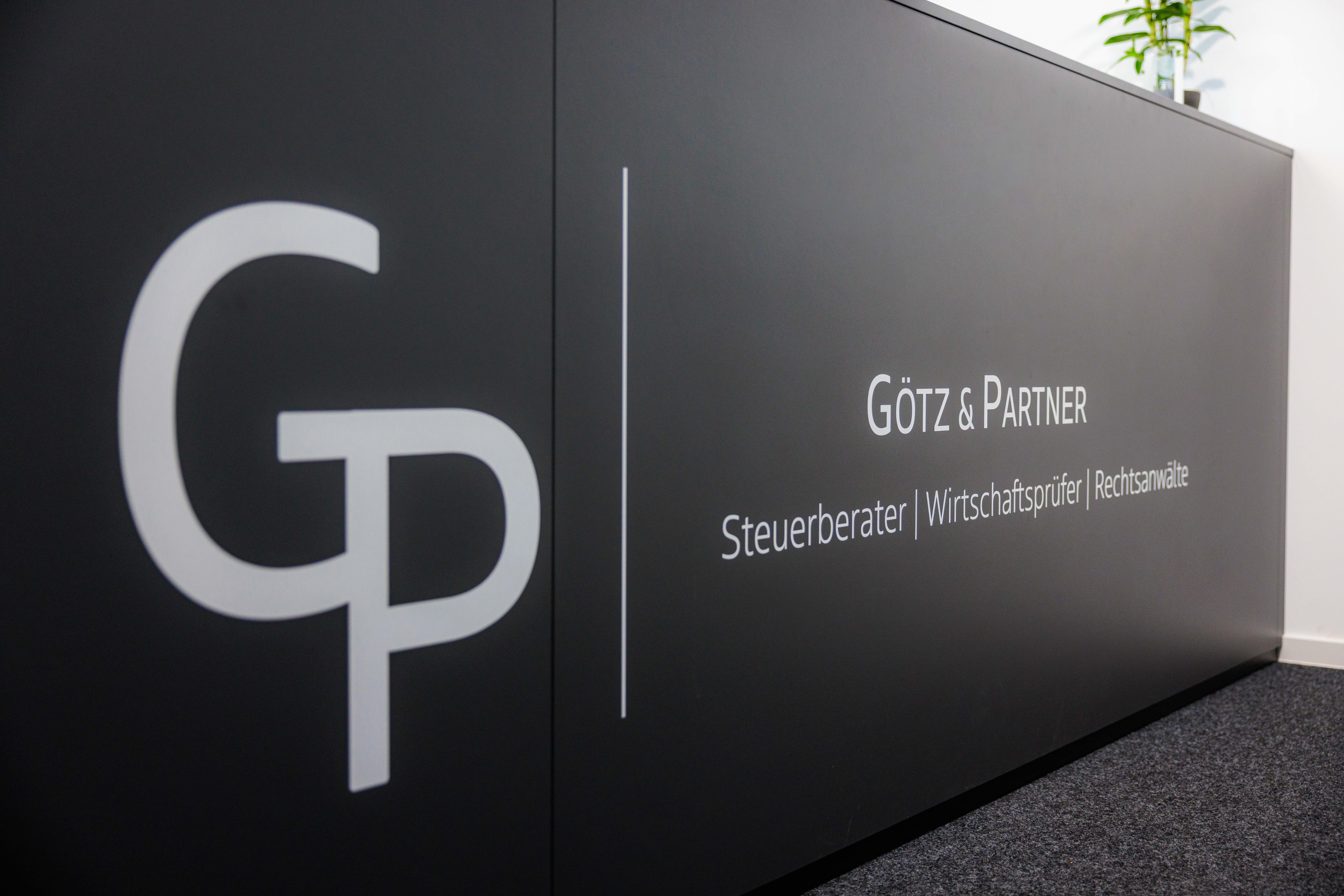 Schwarze Empfangstheke mit dem Logo GP und der Aufschrift Götz & Partner, Steuerberater, Wirtschaftsprüfer, Rechtsanwälte.