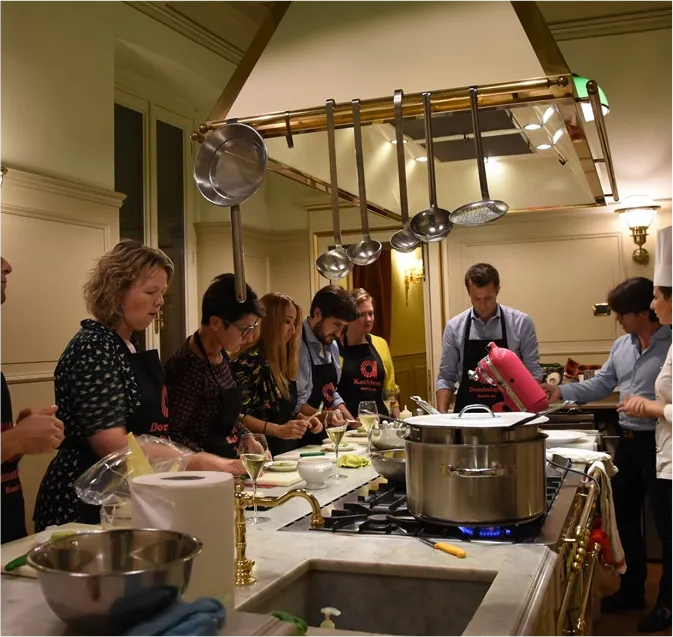 Atelier de team cooking dans un palais historique durant une expérience culinaire exclusive organisée par INÜI Collection.