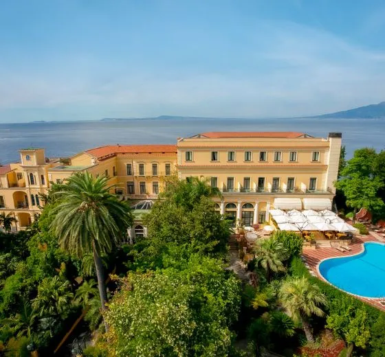Vue sur la façade lumineuse d’un hôtel de Sorrento avec piscine surplombant la mer lors d’un séjour signé INÜI Collection.