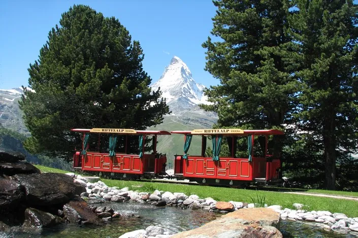 Montée à bord du train rouge menant au Gornergrat pour une expérience unique au cœur des Alpes avec INÜI Collection.