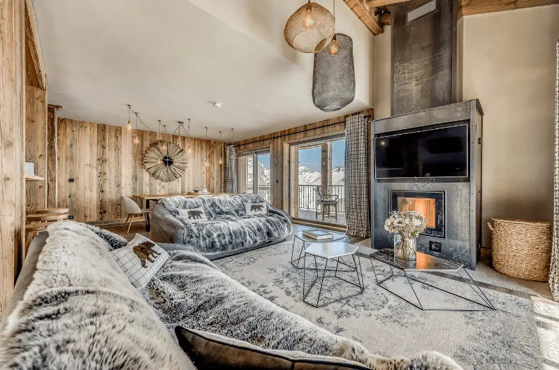 Salon chaleureux avec cheminée dans un refuge alpin de Val d’Isère pour un lancement de produit avec INÜI Collection.