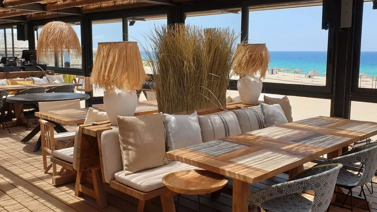Mobilier en bois installé sur une plage paisible de Comporta pour un moment de détente avec INÜI Collection.