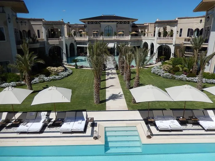 Détente autour de la piscine extérieure dans un cadre d’exception à la palmeraie lors d’un séjour INÜI Collection.