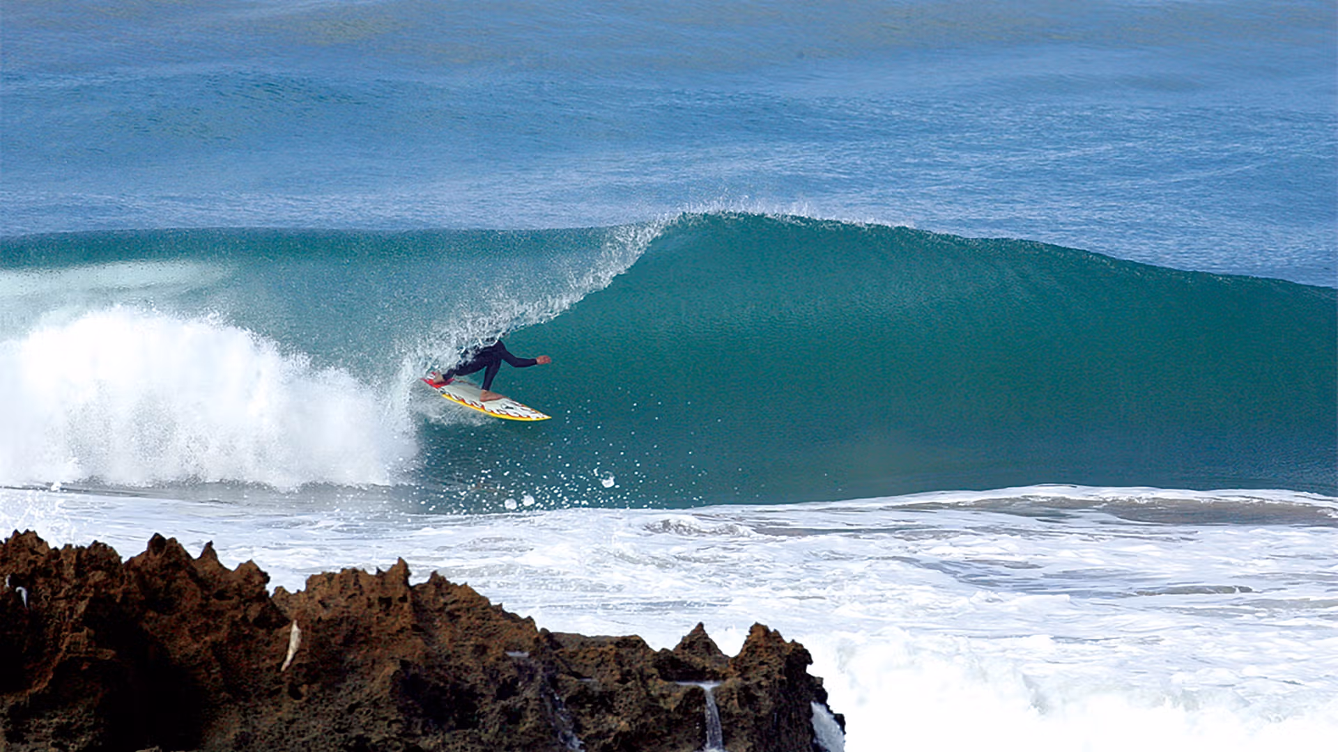 Session de surf sur les vagues réputées de Taghazout pendant un incentive dynamique organisé par INÜI Collection.