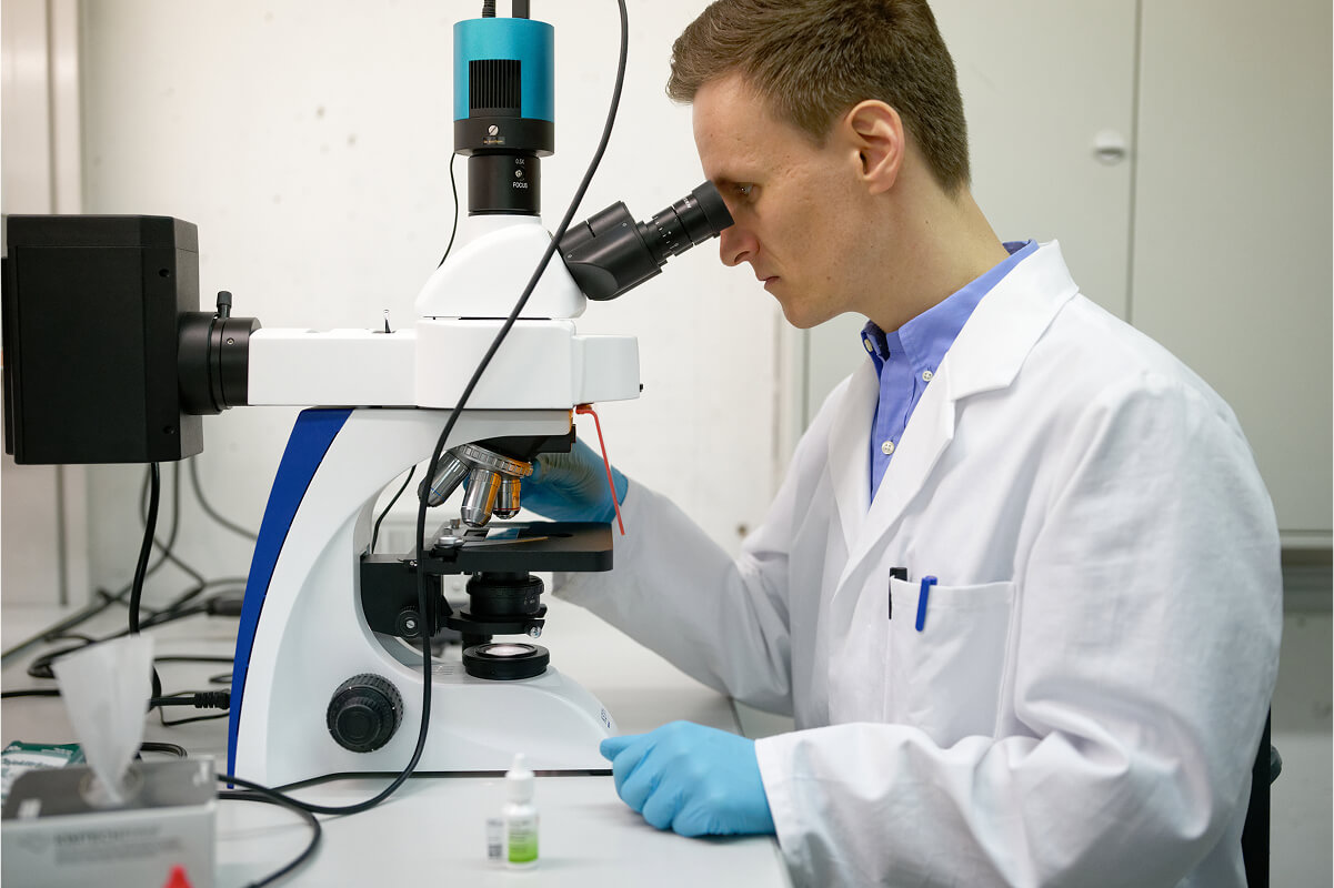 Mycolever scientist looking through microscope