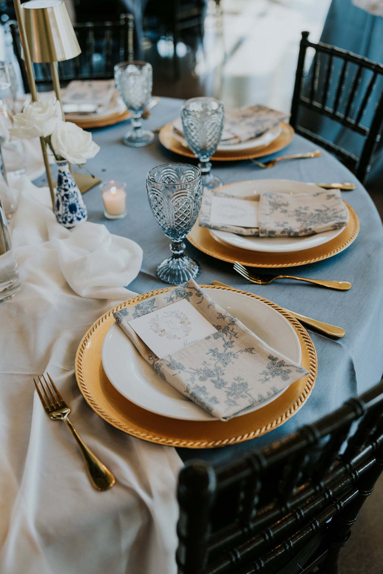 Table setting at a wedding venue with place settings and glassware.