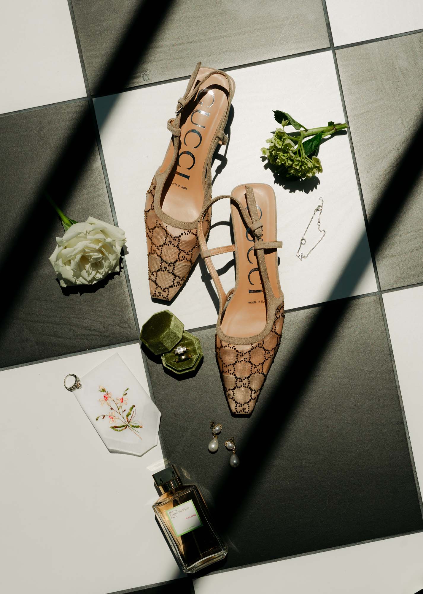 Bridal shoes, greenery, and perfume on a tiled surface for a Smoky Mountains wedding.