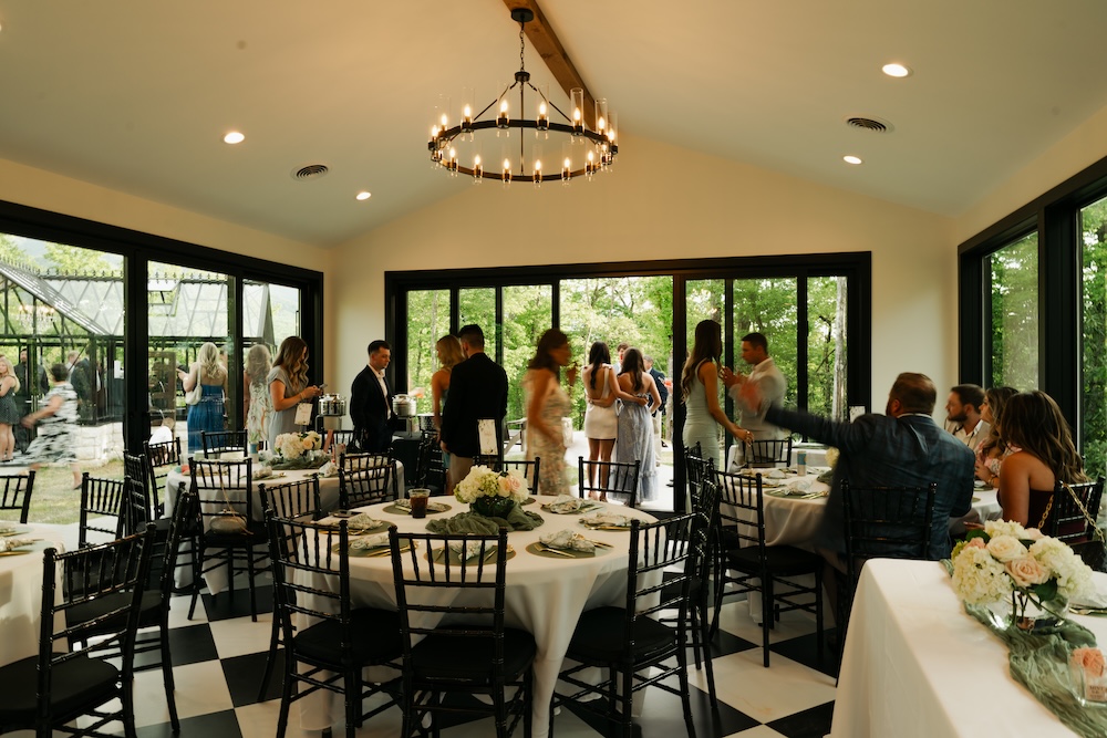 Reception setting with large windows overlooking greenery. Trailhead Venues Gatlinburg, TN.