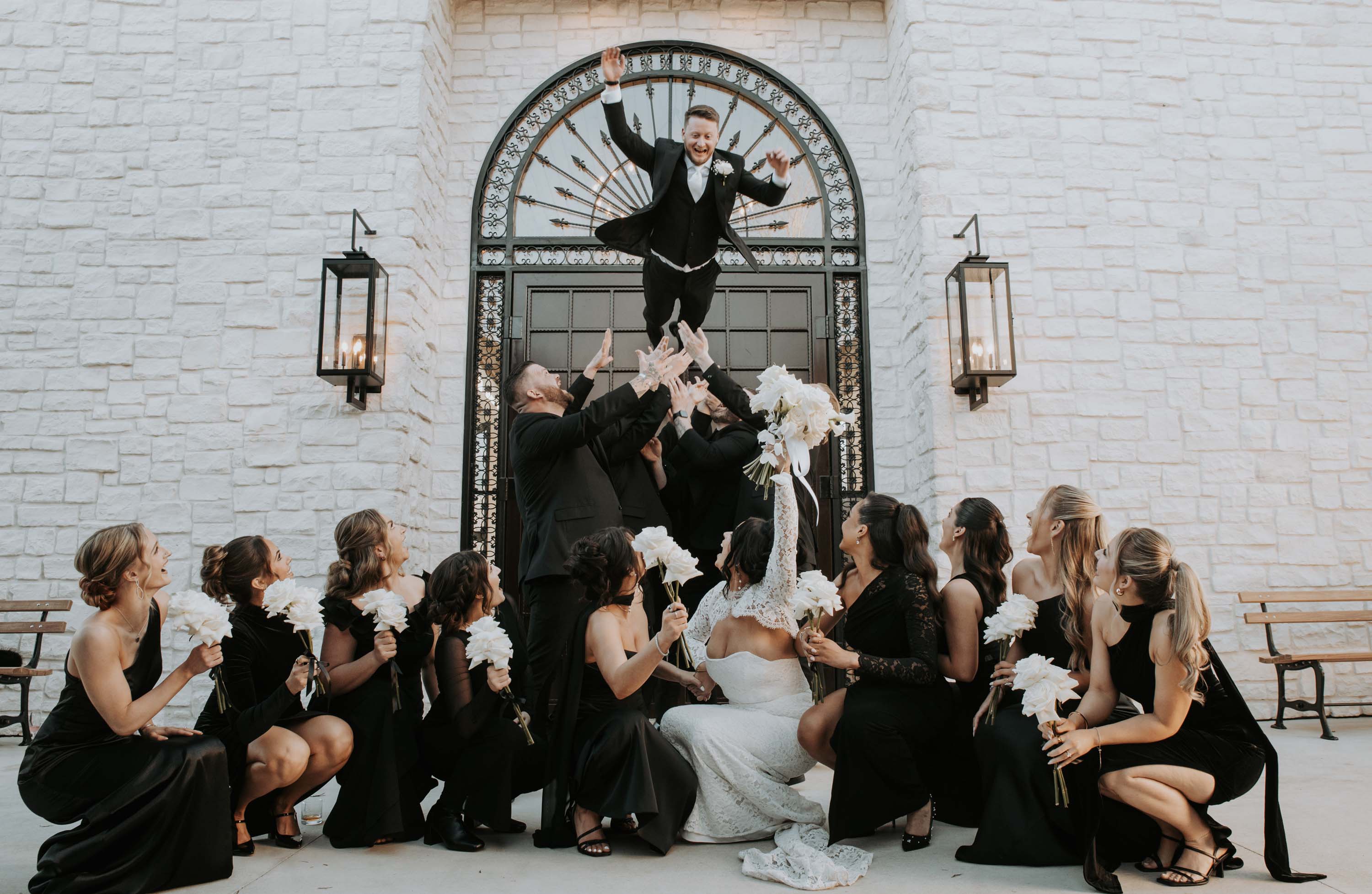Groom jumps through archway into cheering bridal party at a Gatlinburg wedding venue.
