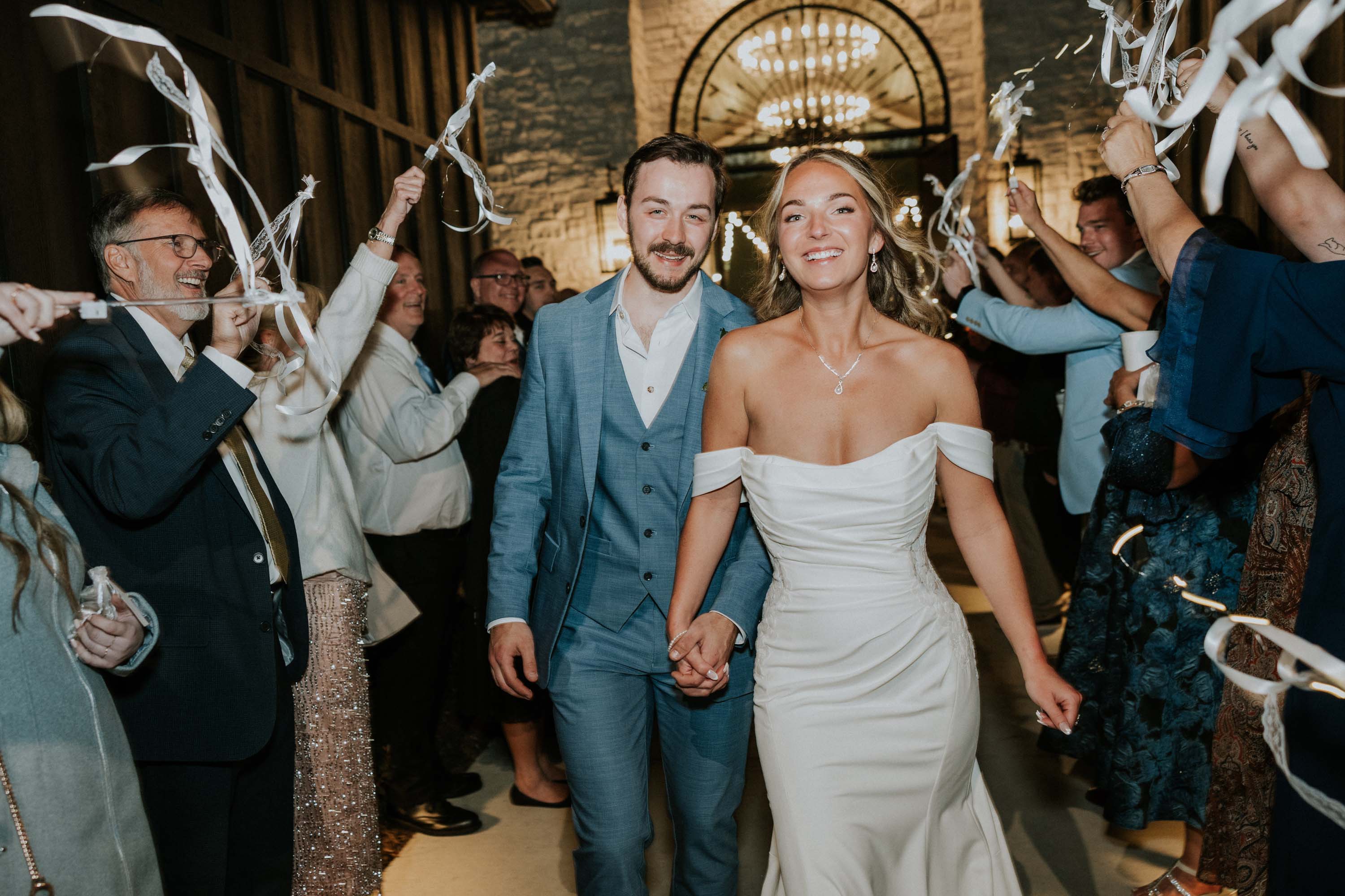 Bride and groom walk through cheering guests at a Gatlinburg wedding venue.