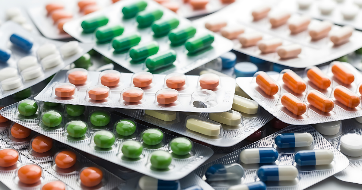 Pharmacien vérifiant la durée de conservation d'une boîte de médicaments dans le tiroir de son officine.