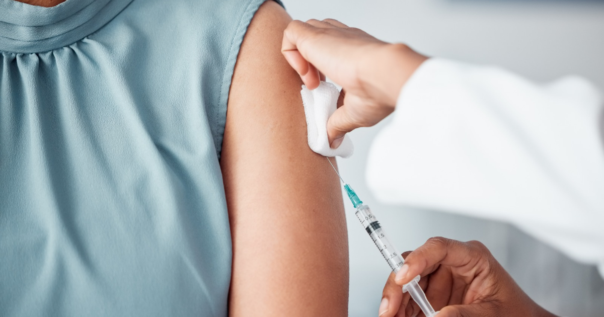 Infirmier libéral réalisant la vaccination grippe d'un patient âgé à domicile pendant la campagne 2026