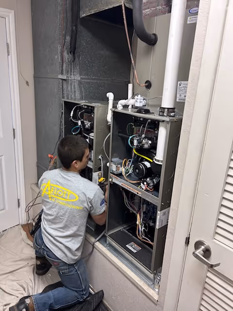 Technician repairing an HVAC system's internal electrical and mechanical components