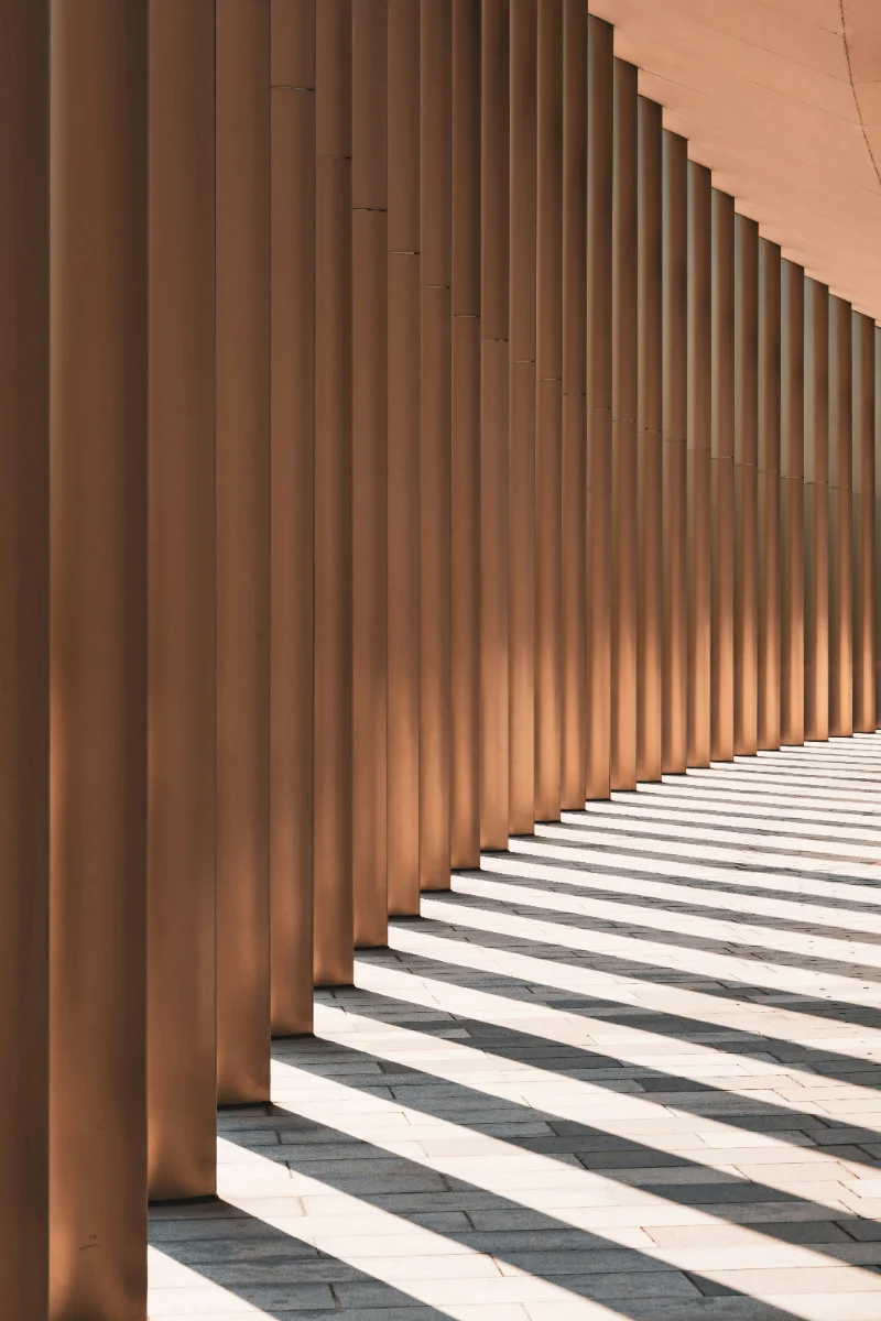 Colonnade of warm stone pillars with sunlight falling across steps