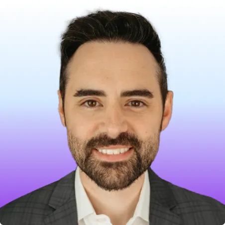 Headshot of a man with dark hair and beard wearing a gray checkered blazer and white shirt smiling against a blue and purple gradient background.