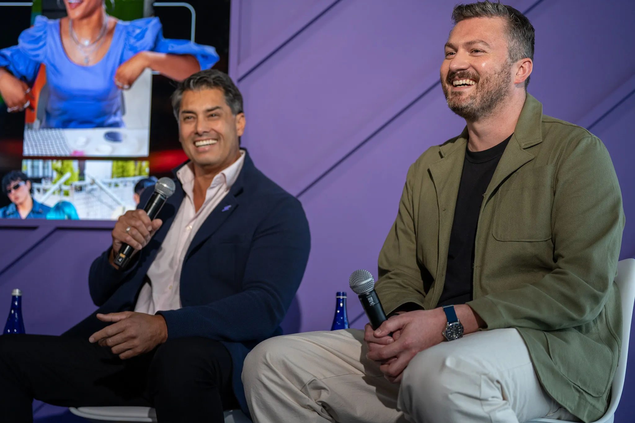 Woman explaining something at a table indoors, speaking to a man while gesturing with her hands.