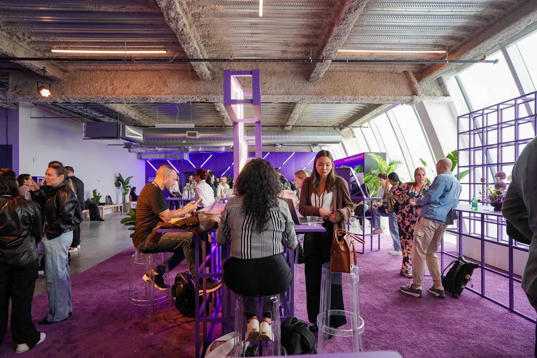 Five attendees posing and smiling in front of large purple "ADVANCE" letters at an indoor venue.
