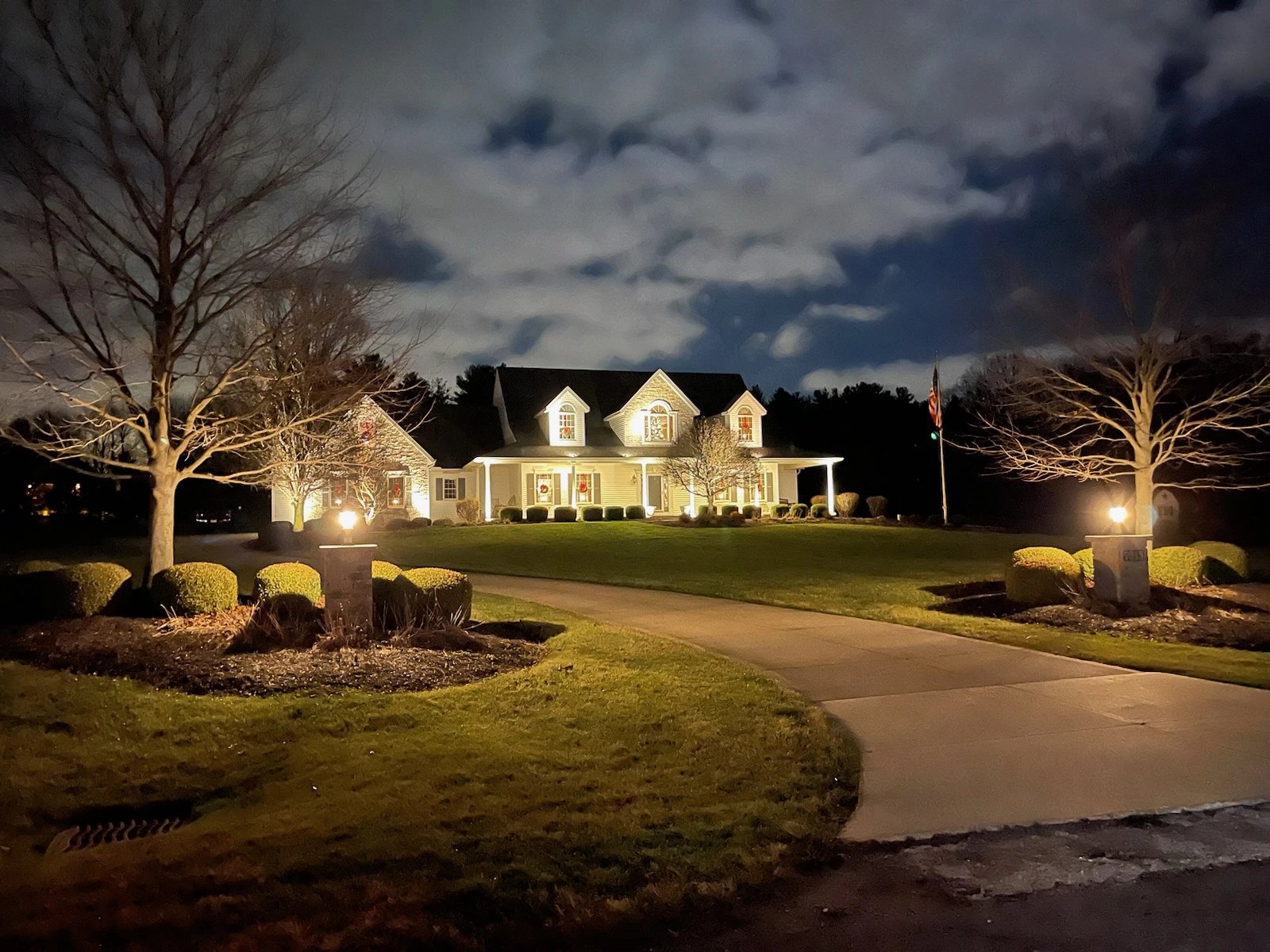 Irrigation & Lighting: Landscape irrigation system and outdoor lighting illuminating a residential property at dusk
