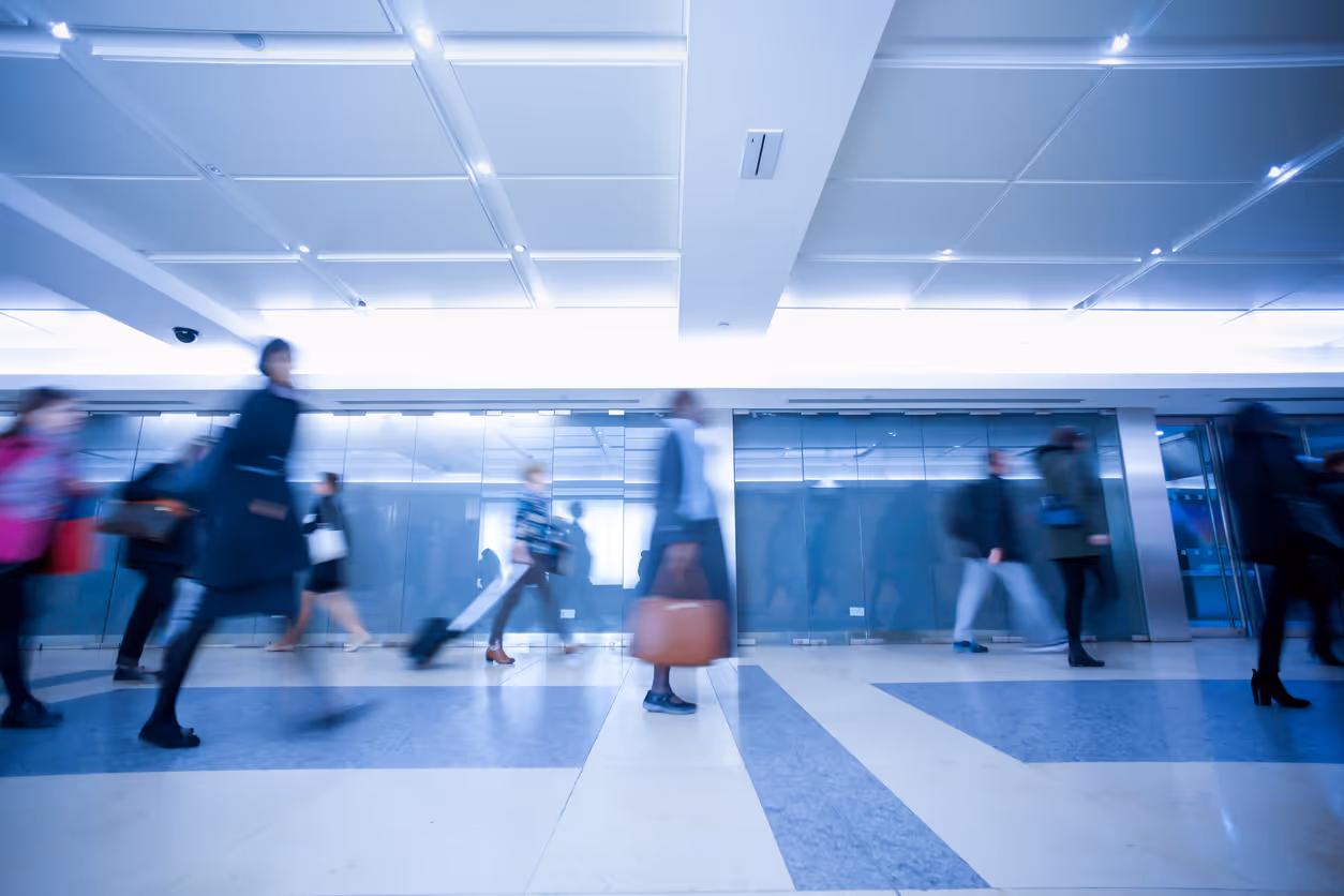 Blurred people walking with luggage in modern airport or subway terminal