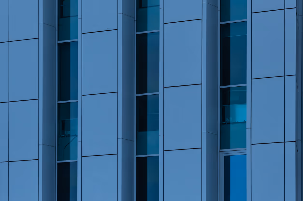 Modern glass building facade with blue and teal geometric window pattern
