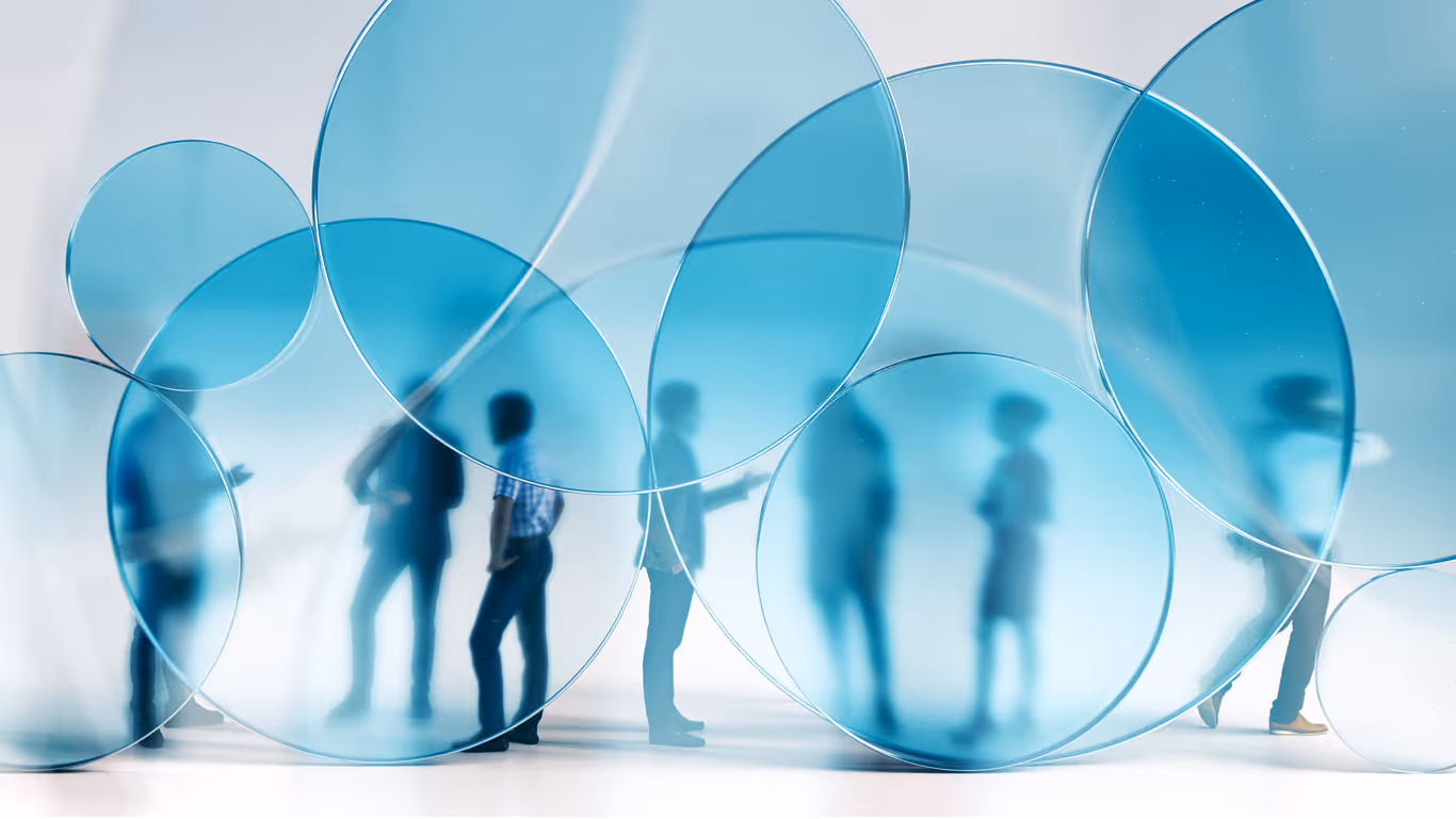 Silhouettes of six people visible through large translucent blue circular panels, suggesting communication or separation.