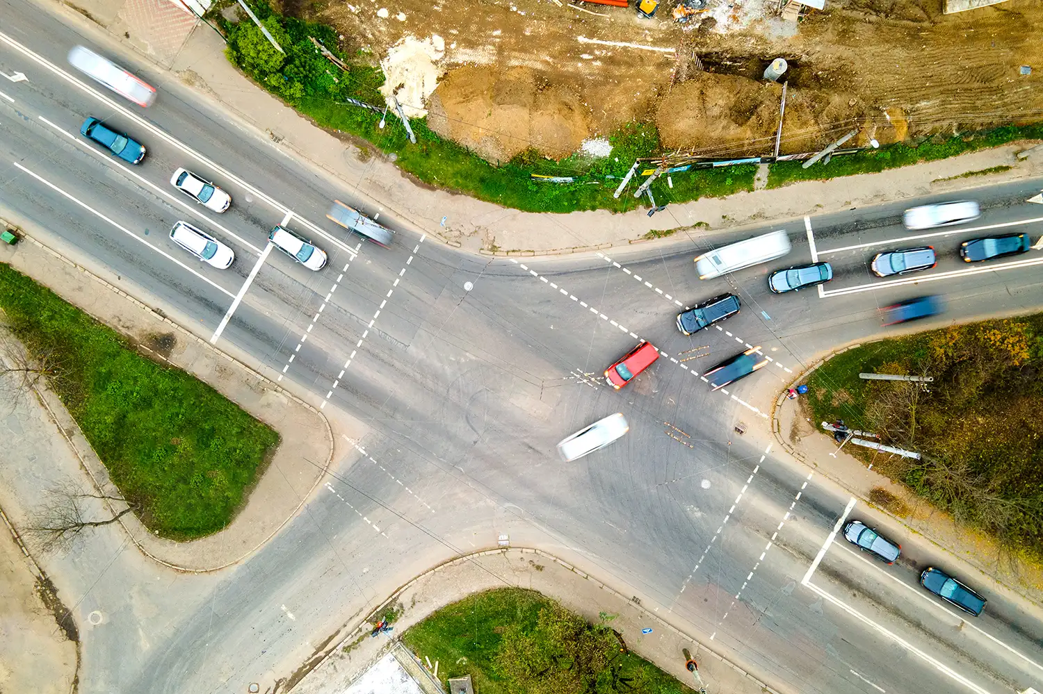 Cars cross intersecting 3-lane and 4-lane roads