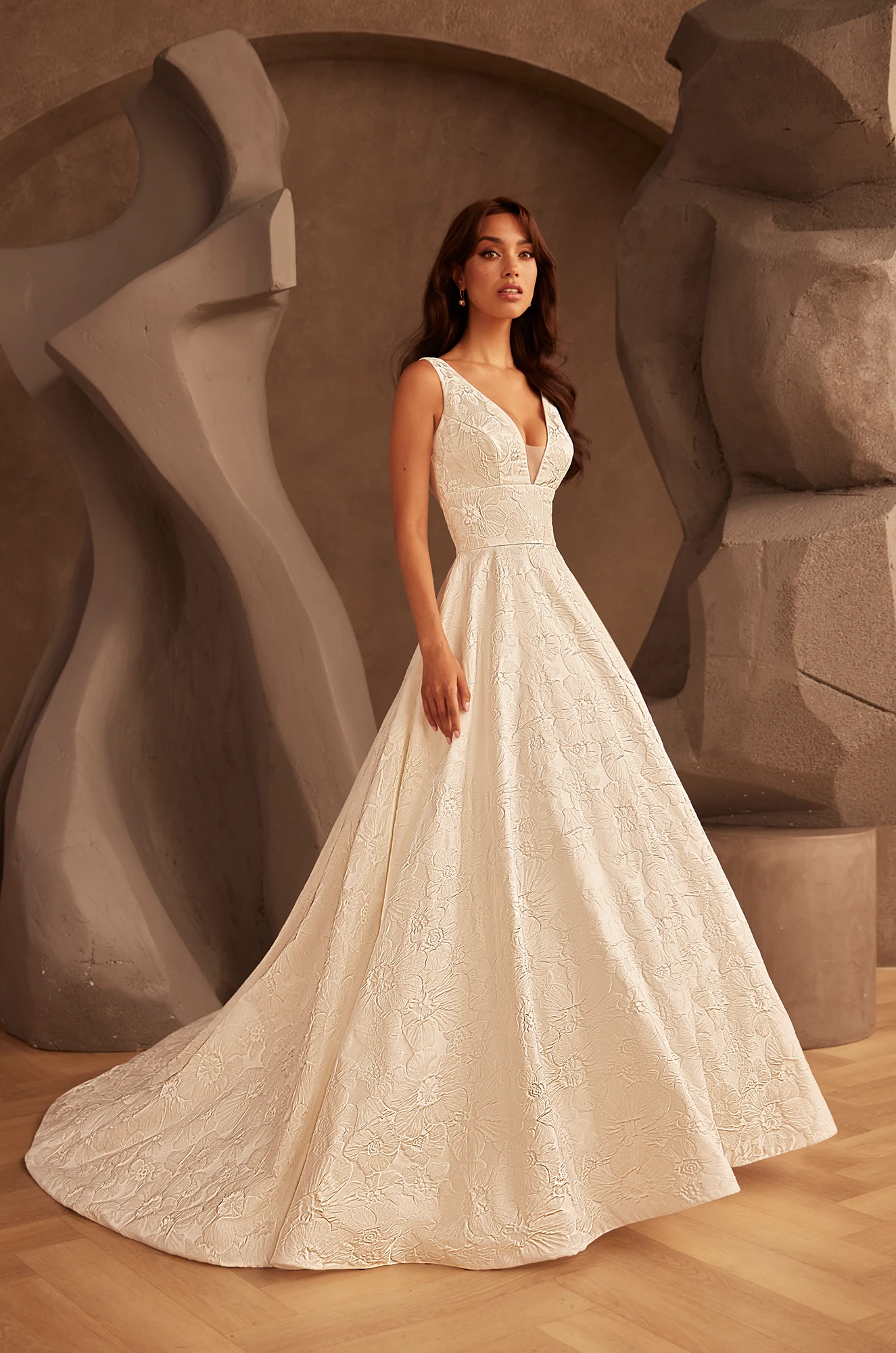 V-neckline embroidered wedding dress with floral pattern, fitted waist and ball gown train. 