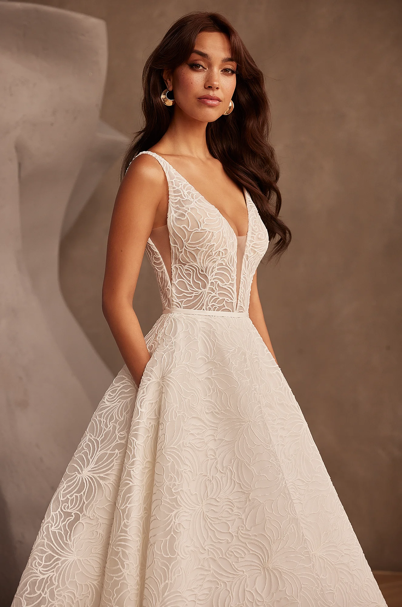 Deep V-neckline wedding dress with floral embroidery, fitted bodice and ball gown skirt.