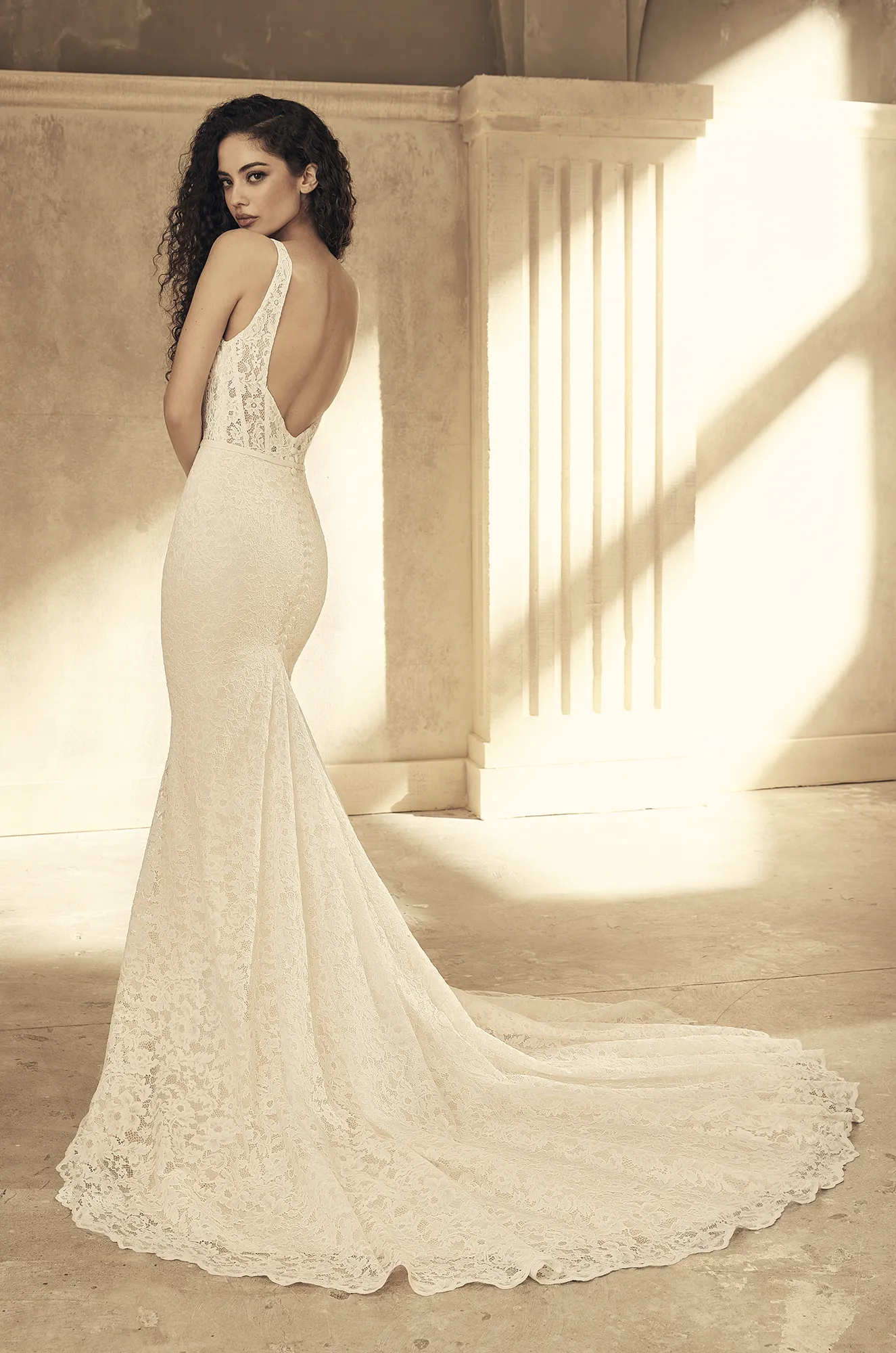 Wedding dress back view showing square neckline and fitted lace mermaid silhouette train.