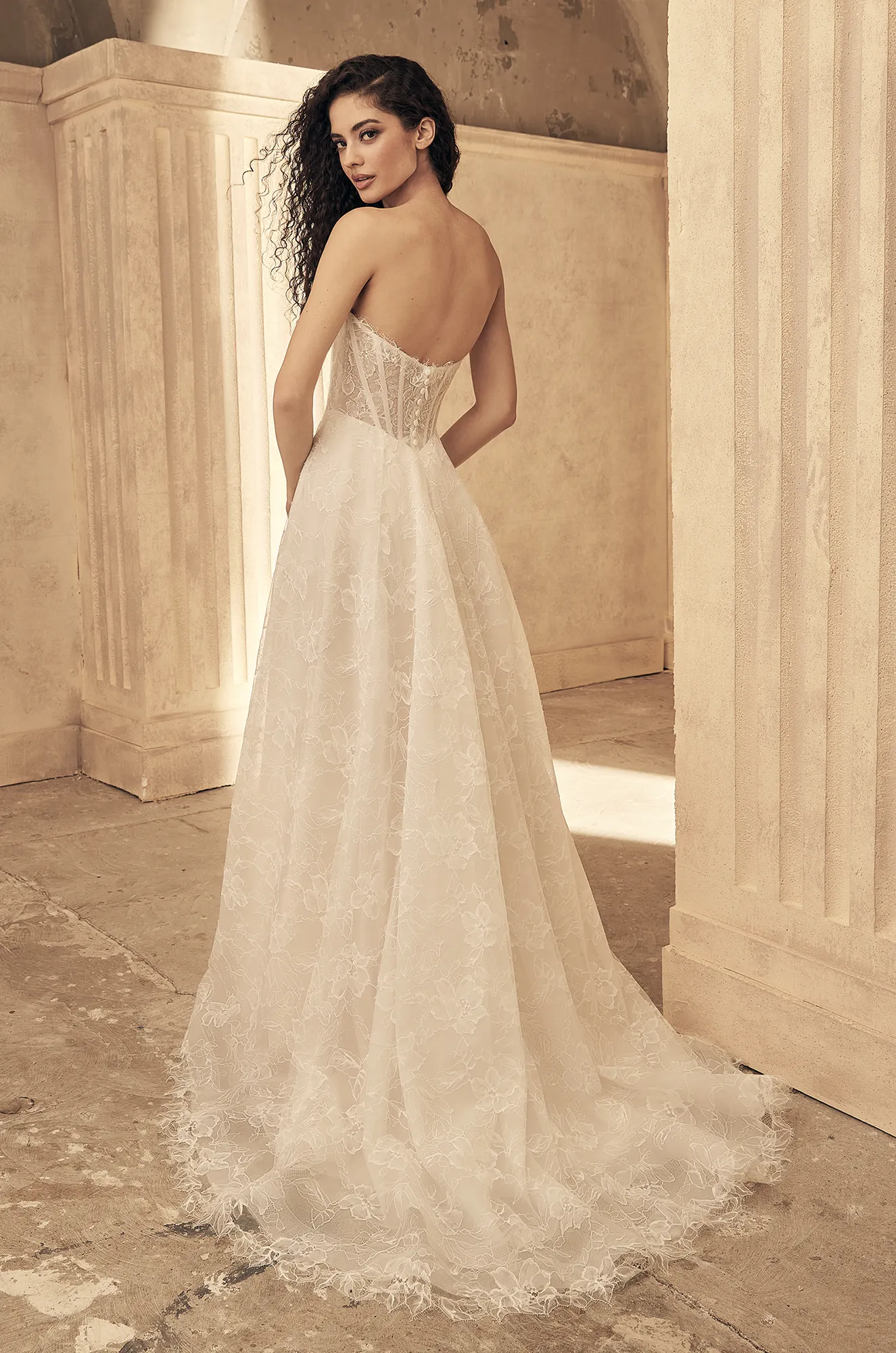 Ivory wedding dress back view showing off-shoulder lace design and flowing A-line lace train.