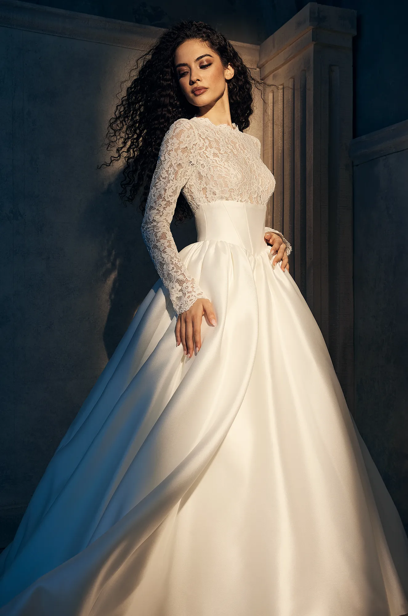 Classic bridal gown featuring a lace high-neck top with long sleeves and a voluminous satin skirt.