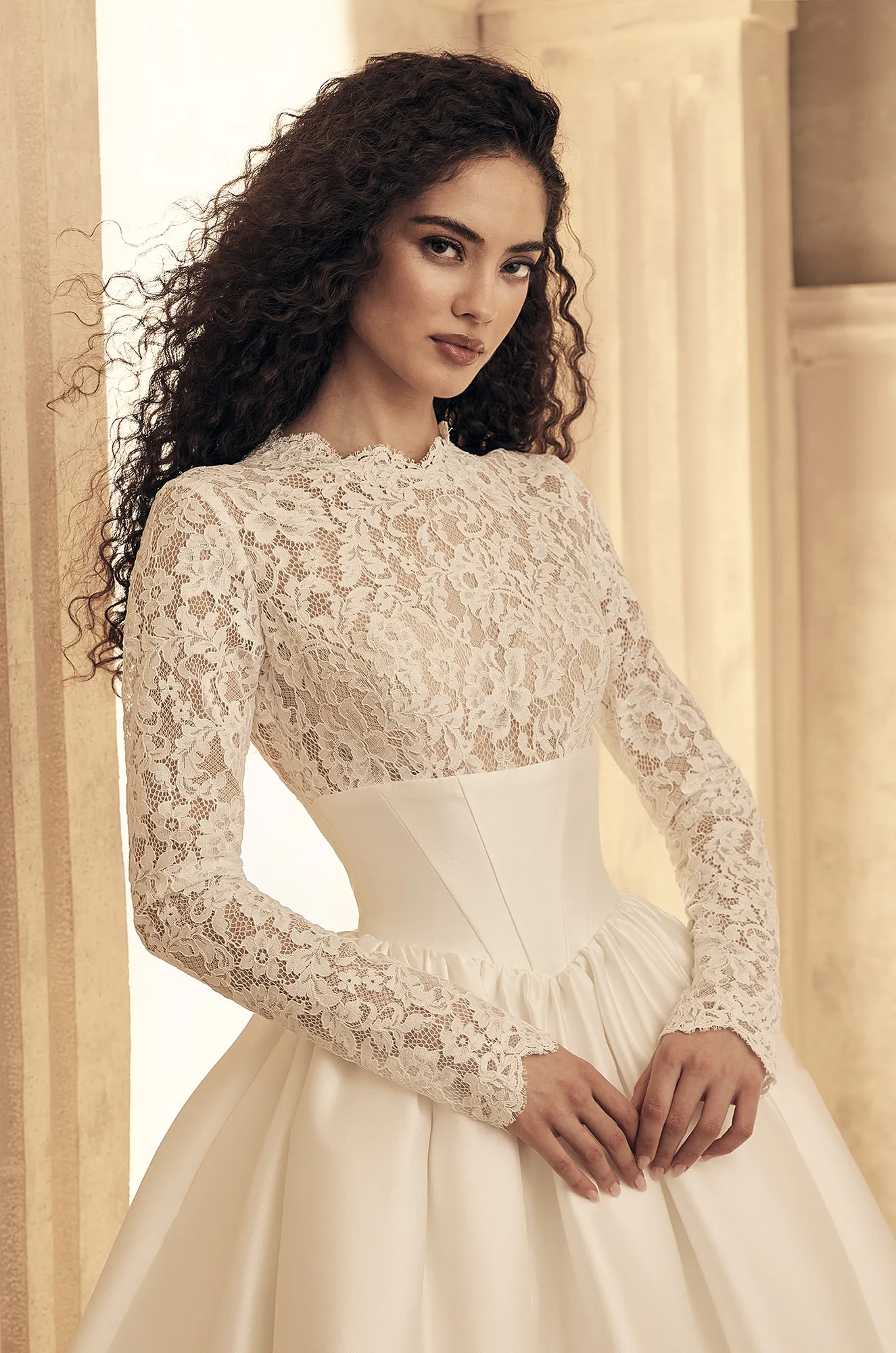 Wedding dress close-up showing long sleeve lace bodice detail and fitted waistline.