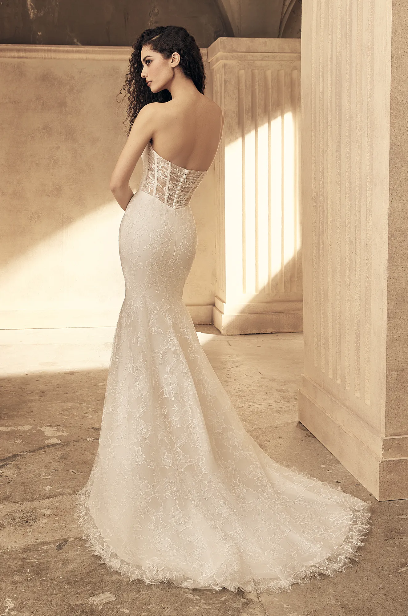 Lace wedding dress back view showing strapless design and fitted mermaid train detail.
