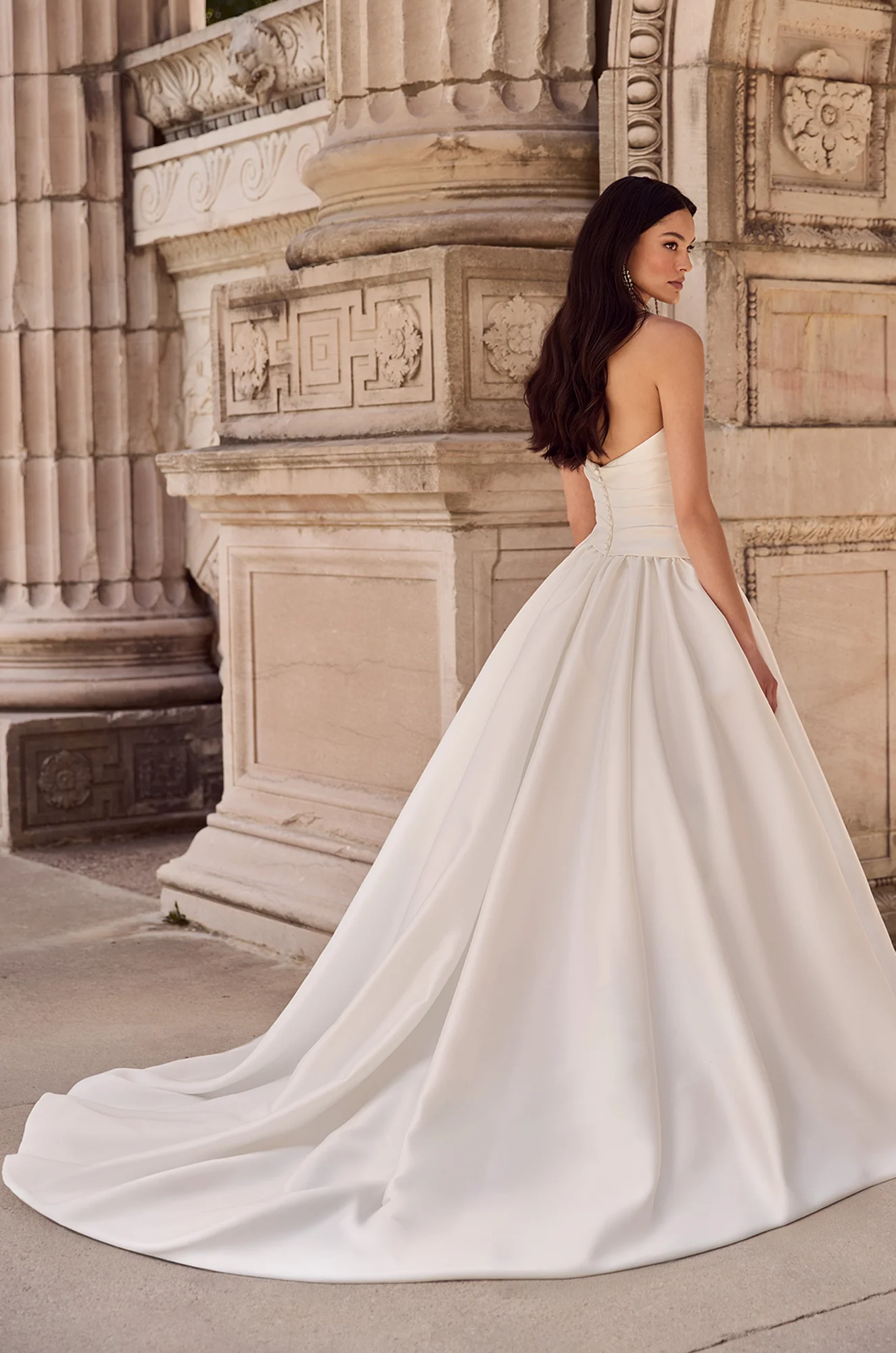Wedding dress back view showing strapless neckline and flowing ball gown silhouette.