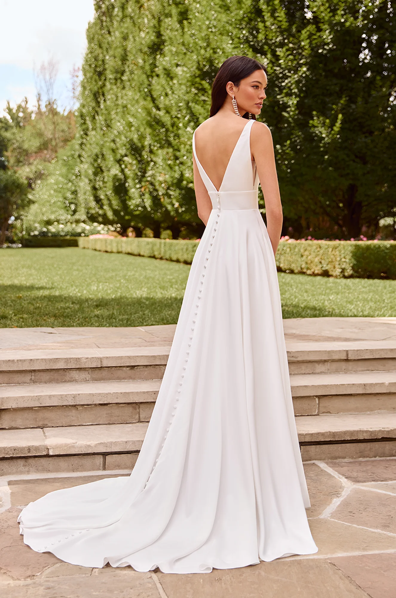 Wedding dress back view showing V-neckline and flowing chiffon A-line silhouette train.