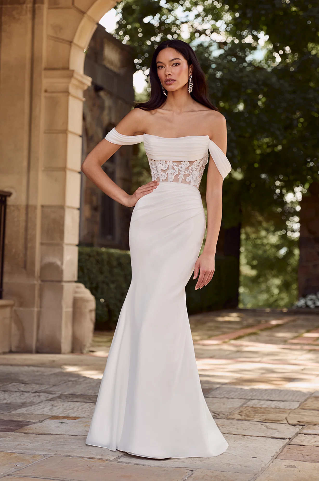 Front view of off-shoulder wedding dress with lace corset bodice, ruched waist and mermaid silhouette.